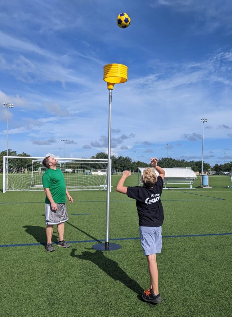 Father and son practicing Korfball on a synthetic turf field in Viera Regional Park, Florida 